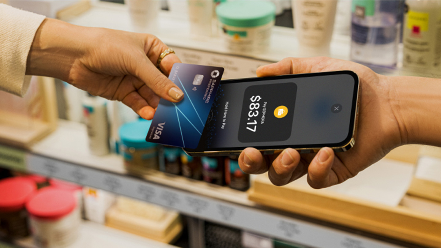 Customer tapping credit card against a card reader in a store